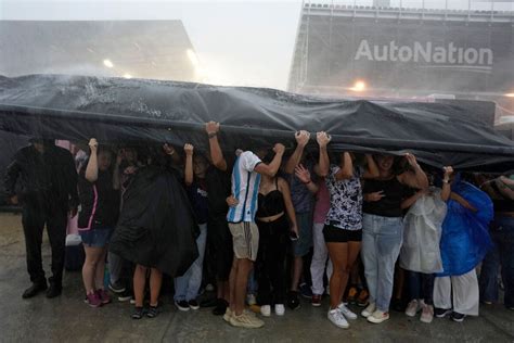 Torrential downpour no obstacle for soccer fans waiting to see Messi at DRV PNK Stadium